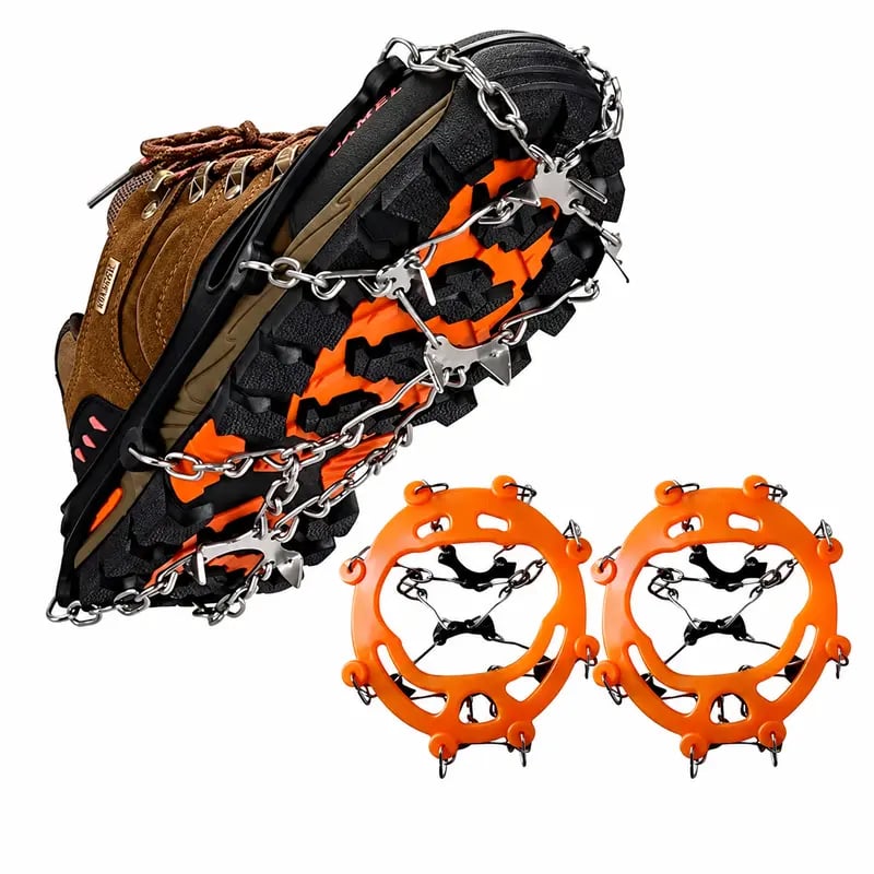 Pair of orange ice cleats beside a winter boot