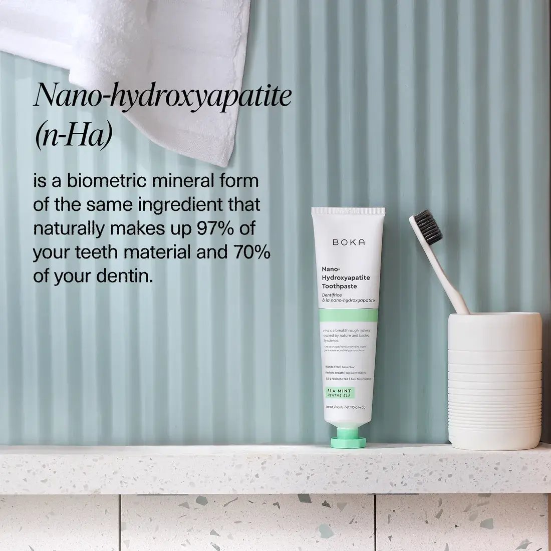 Boka Nano-hydroxyapatite toothpaste tube with a toothbrush on a bathroom shelf.